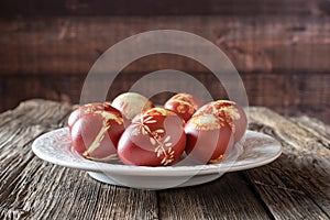 Easter eggs dyed with onion peels with a pattern of fresh herbs on a plate
