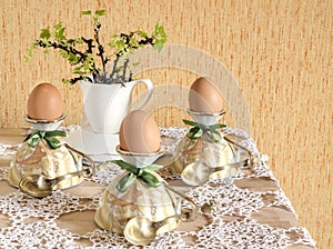 Easter eggs in eggcups with gold spoons