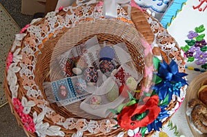 Easter eggs on embroidered towels in a straw basket.