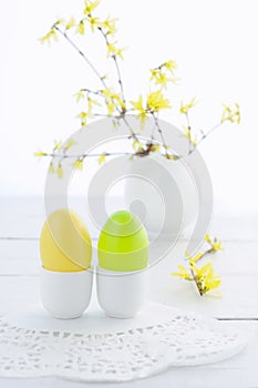 Easter eggs and flowering branches on wooden table
