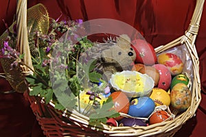 Easter eggs with flowers and a hedgehog in a basket
