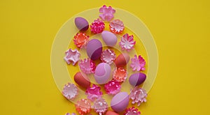 Easter eggs and flowers made of paper on a yellow background. The colors are pink, burgundy, fuchsia and yellow. Spring.