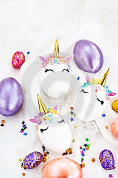 Easter eggs in the form of a unicorn on white background, copy space for text, top view