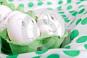 Easter eggs with funny faces in the green