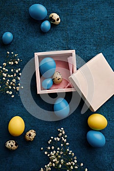 Easter eggs in gift box on blue cloth background