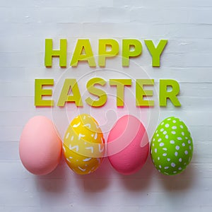 Easter eggs and HAPPY EASTER text on light backdrop