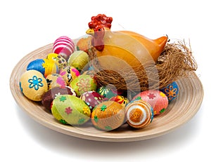 Easter eggs and hen with nest on plate