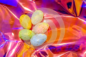 Easter eggs on holographic background. Trend of the year.