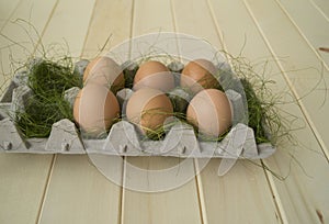 Easter. Eggs lie in the container for eggs. Green grass.