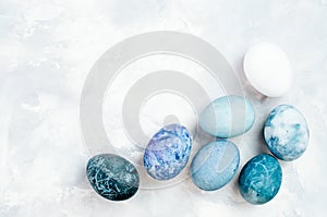 Easter eggs with marble stone effect painted with natural dye carcade flower on grey concrete background