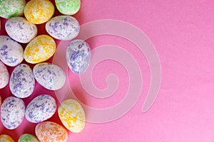 Easter eggs are multicolored on a pink background. Holiday. Eggs are small from foam plastic. Copy space. View from photo