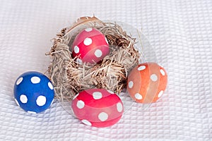 Easter eggs near birds nest on checkered white background