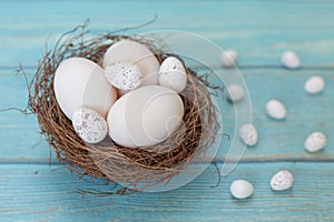 Easter eggs in nest on the blue background.Flat lay style.