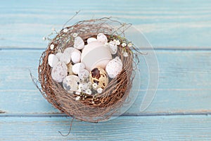 Easter eggs in nest on the blue table background.Flat lay style.