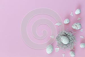 Easter eggs in nest on the pink background.Flat lay style.