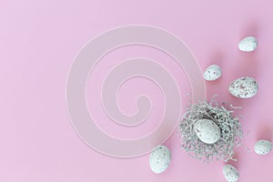 Easter eggs in nest on the pink background.Flat lay style.