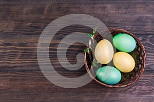 Easter eggs in the nest on rustic wooden background