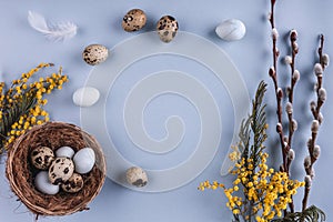 Easter eggs in nest and spring flowers on holiday background.
