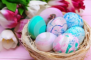 Easter eggs in a nest and tulips on wooden planks