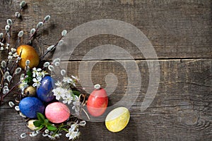Easter eggs in a nest with willow branches and spring flowers