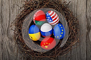 Easter eggs painted in the colors of the flags of different states of the world in the nest