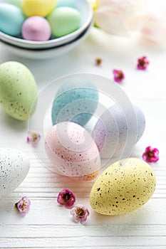 Easter eggs painted pastel colors on a white wooden background