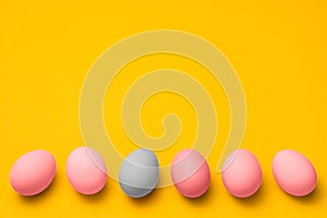 Easter eggs painted in pink and blue pastel colors on a yellow background with copyspace. easter advertise minimalist
