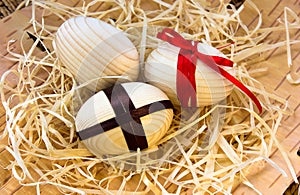 Easter eggs with ribbon and red flowers. Background birch bark and straw