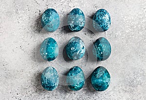 Easter eggs row painted by hand in blue color on light background