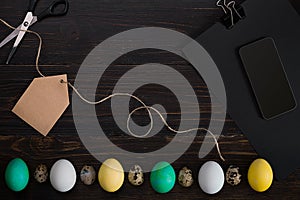 Easter eggs, scissors and thread on a black background