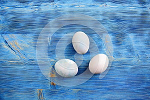 Easter eggs in soft colors on a blue shabby wooden table