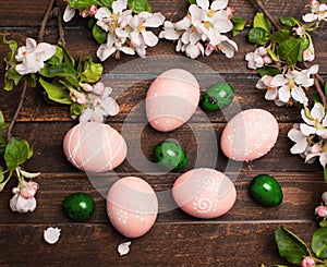 Easter eggs with spring blossom flowers on rustic wooden background. Decorated Egg Holiday art design background. Easter.