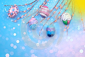 Easter eggs with spring branches with buds on a light  blue shine  background.