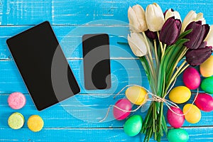 Easter eggs and tulips on blue wooden planks