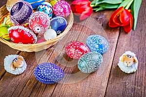 Easter eggs with tulips on weathered wooden background