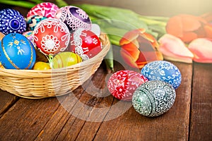 Easter eggs with tulips on weathered wooden background