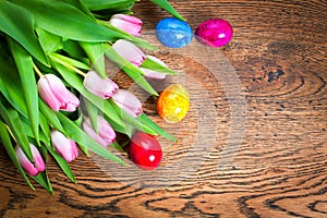 Easter eggs and tulips on wooden planks