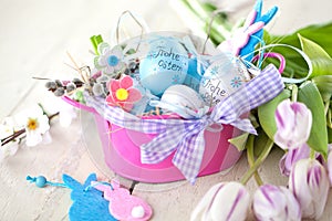 Easter eggs and tulips on wooden planks.