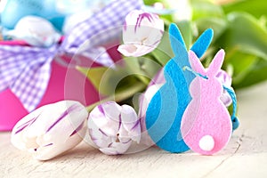 Easter eggs and tulips on wooden planks.