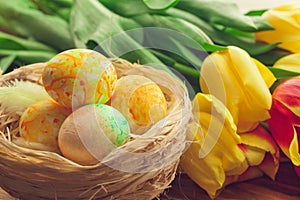 Easter eggs and tulips on wooden planks