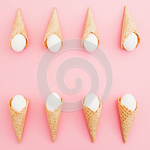 Easter eggs in waffle cones on pastel pink background. Top view, Flat lay. Easter frame concept
