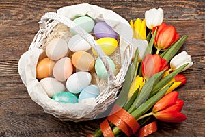 Easter Eggs in a white basket with colorful tulips