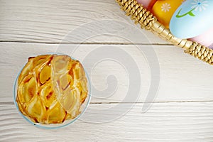 Easter Eggs in Wicker Basket and Apple Pie table top view copy space stock photo