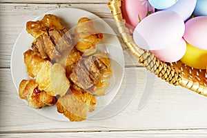 Easter Eggs in Wicker Basket and Croissants table top view copy space stock photo