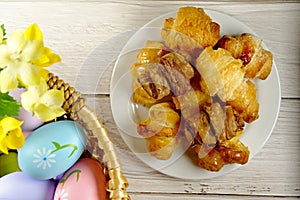 Easter Eggs in Wicker Basket and Croissants table top view copy space stock photo