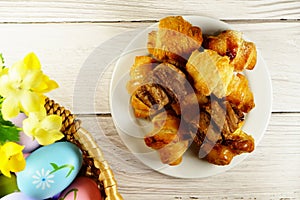 Easter Eggs in Wicker Basket and Croissants table top view copy space stock photo