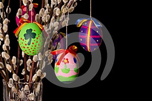 Easter eggs on willow bouquet on black background