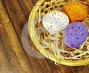 Easter eggs on a wooden in a baskett concept vibrant space