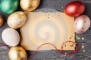 Easter eggs on wooden table with blank paper for text.