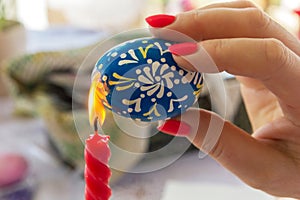 On Easter Eve, a woman paints an Easter egg